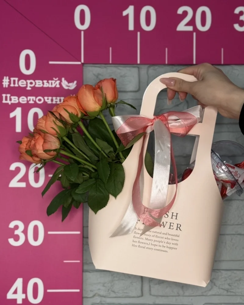 Цветы в сумочке с оранжевыми розами и сладостями